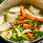 Homemade chicken noodle soup simmering with tender chicken, carrots, celery, onions, and fresh parsley in a golden broth.