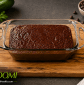 Moist homemade chocolate zucchini bread baked in a glass loaf pan, made with almond flour, organic applesauce, cacao powder, maple syrup, avocado oil, and fresh grated zucchini for a wholesome gluten-free dessert.